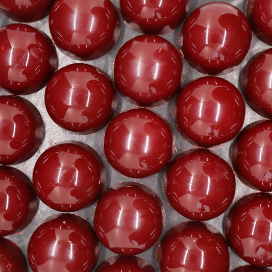 Overhead shot of array of red handmade chocolate bonbons