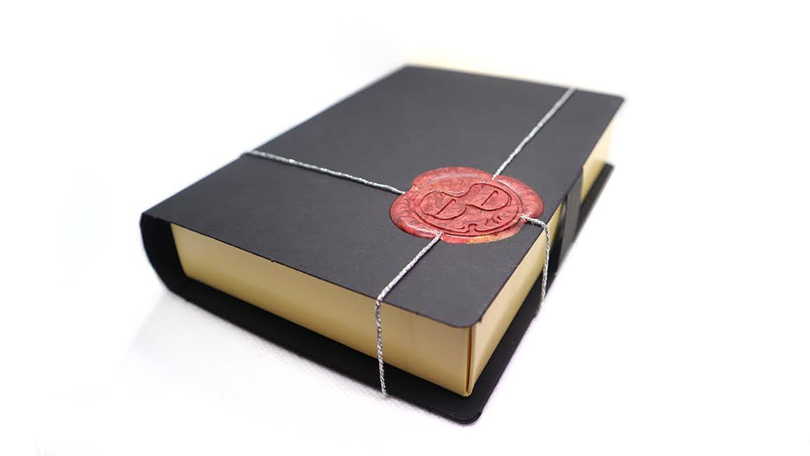 Sealed box with a wax seal containing chocolate bonbons by Dark Desires